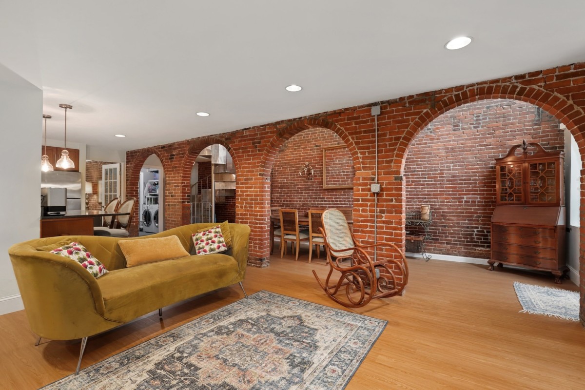 living room with arched hallway walls running through the space