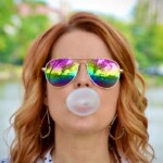person in sunglasses blowing a bubble